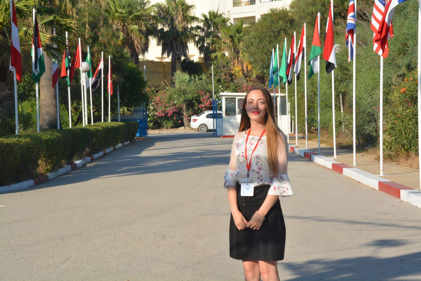 A participant standing on an avenue lined with national flags