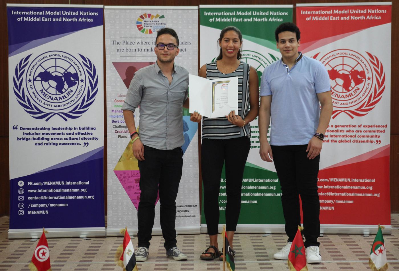 A participant receiving a certificate in front of the forum banners