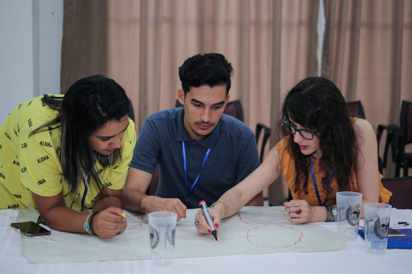 Three participants mapping ideas on paper